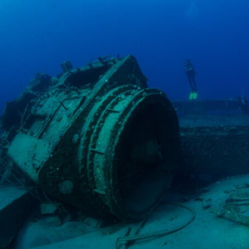 Divers_swimming_close_to_an_enormous_part_of_the_engine__